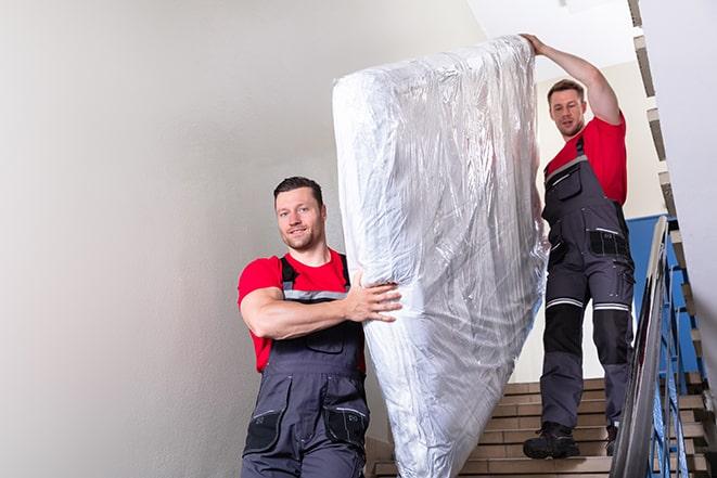 heavy lifting of a box spring during home renovation in Montgomery